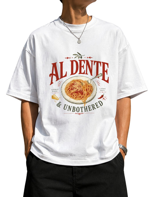 "Oversized White graphic t-shirt featuring a detailed vintage-style illustration of spaghetti on a plate with a fork, parmesan cheese, and a chili pepper, with the text 'AL DENTE' in bold and '& UNBOTHERED"