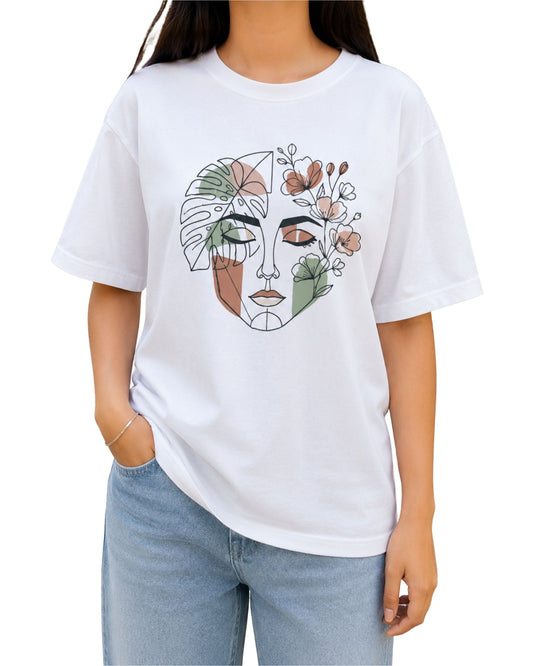 White graphic T-shirt featuring an abstract line-art female face intertwined with botanical leaves and flowers.