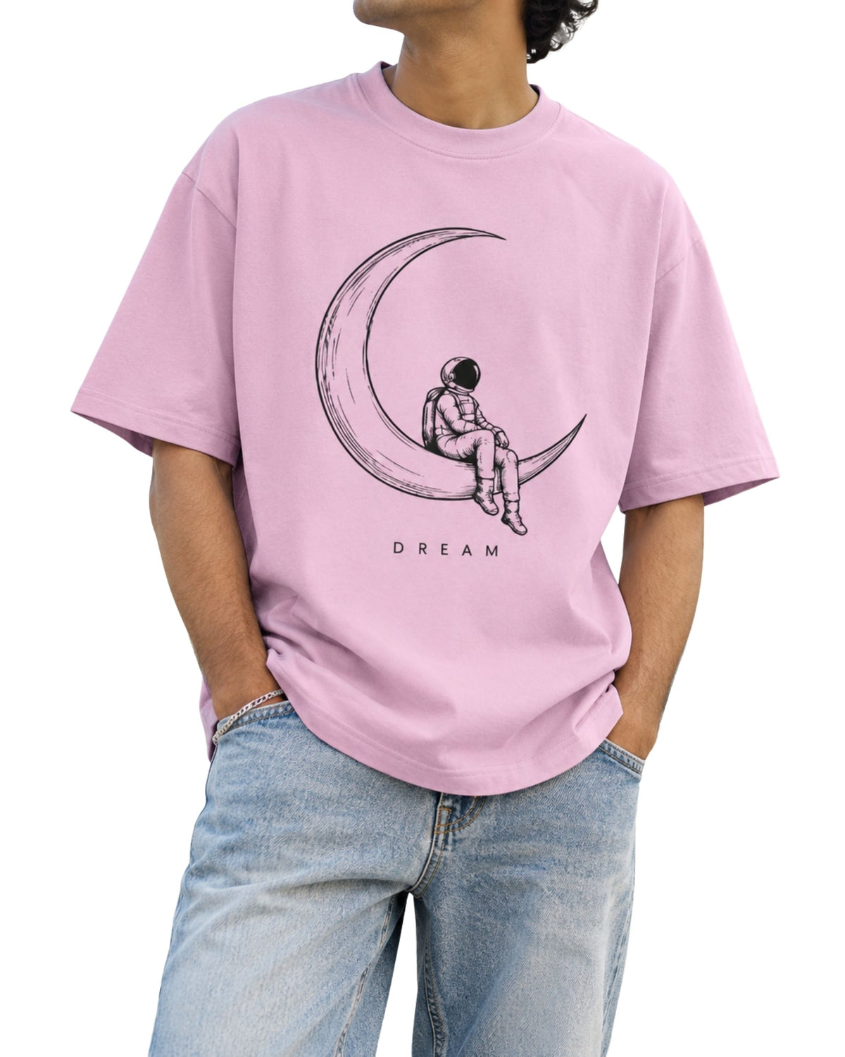 Astronaut sitting on crescent moon DREAM graphic on unisex oversized T-shirt light baby pink