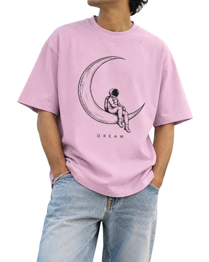 Astronaut sitting on crescent moon DREAM graphic on unisex oversized T-shirt light baby pink
