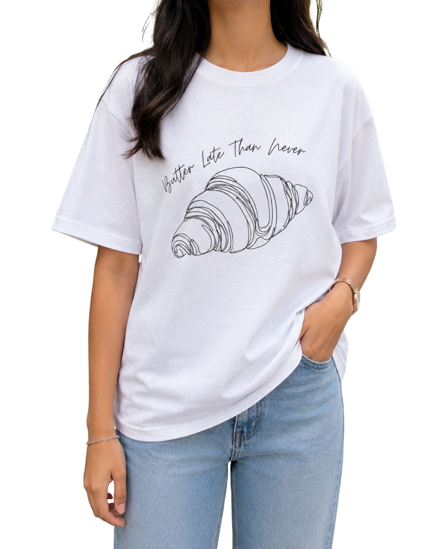 Minimal line-art croissant illustration with the handwritten phrase “Butter Late Than Never” curved above it white