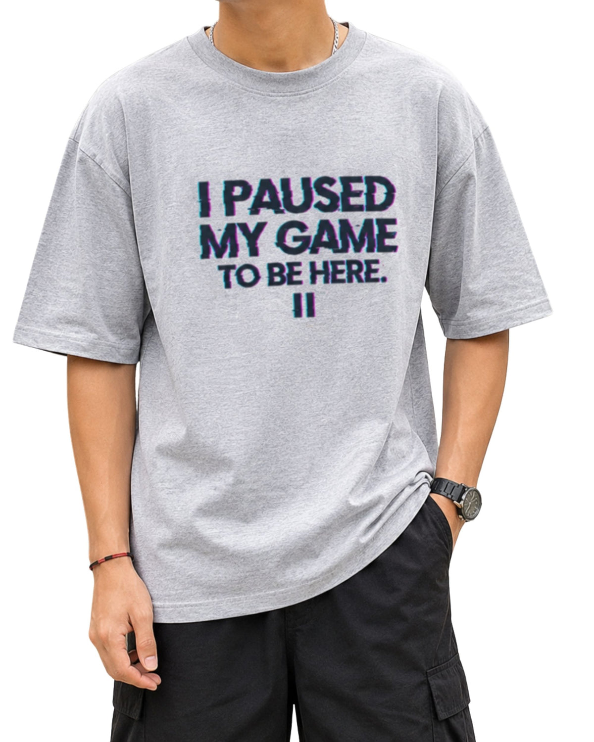 grey melange oversized graphic T-shirt with bold glitch-style text reading “I PAUSED MY GAME TO BE HERE” and a pause symbol underneath, designed with lettering.
