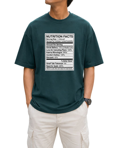 Oversized T-shirt featuring a humorous Introvert Nutrition Facts graphic with social battery, cancelling plans, small talk tolerance, sarcasm, and need for quiet details petrol blue