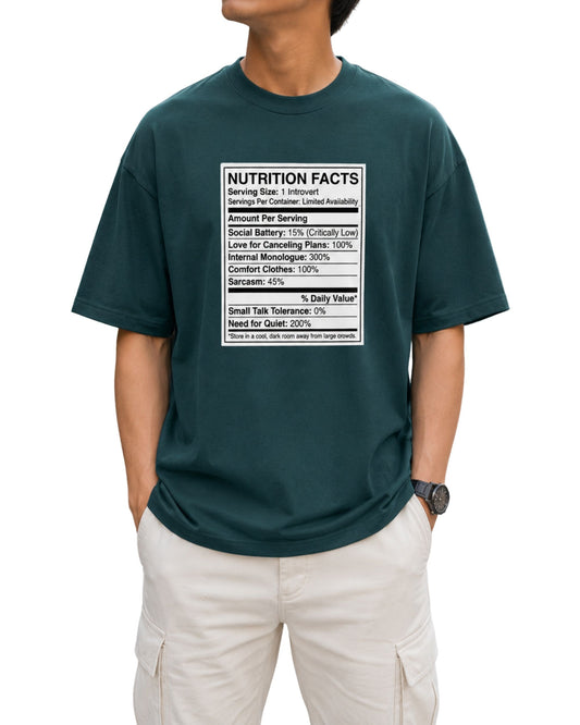 Oversized T-shirt featuring a humorous Introvert Nutrition Facts graphic with social battery, cancelling plans, small talk tolerance, sarcasm, and need for quiet details petrol blue