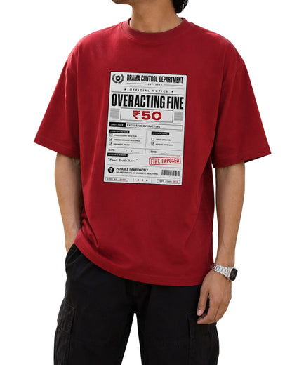 Model wearing a red oversized graphic T-shirt with a “Drama Control Department – Overacting Fine ₹50” print, styled with cargo pants.
