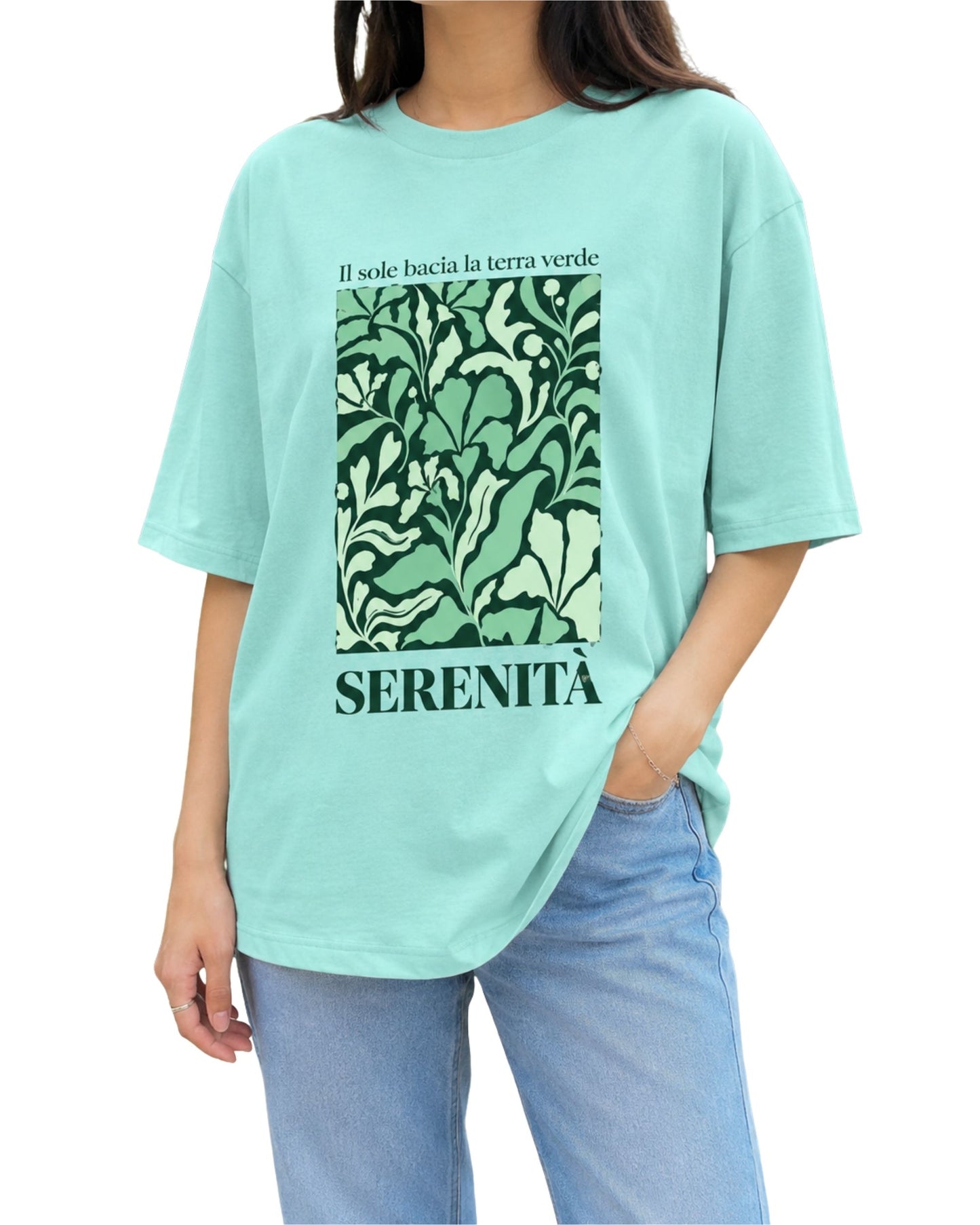 Mint oversized T-shirt design with botanical artwork, Italian text “Il sole bacia la terra verde,” and bold “SERENITÀ” typography.