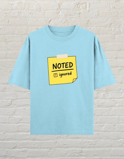 CoreTeez baby blue oversized cotton t-shirt featuring a yellow sticky note graphic with Noted and Ignored text.