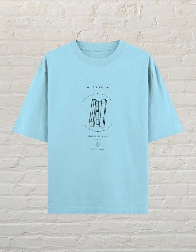 CoreTeez baby blue oversized unisex cotton t-shirt with a black sci-fi TARS graphic print on a brick wall background.