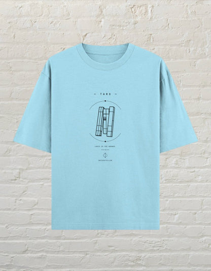 CoreTeez baby blue oversized unisex cotton t-shirt with a black sci-fi TARS graphic print on a brick wall background.