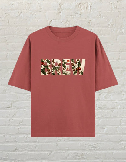 CoreTeez oversized cotton t-shirt in coral featuring a botanical coffee-themed graphic print on the front.