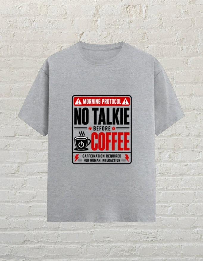 CoreTeez grey melange unisex cotton t-shirt featuring a No Talkie Before Coffee graphic print on a brick wall background.