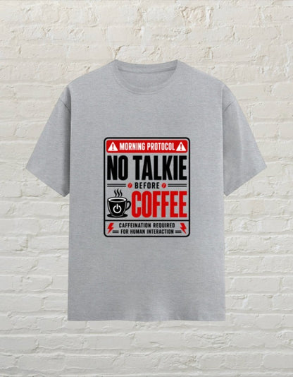 CoreTeez grey melange unisex cotton t-shirt featuring a No Talkie Before Coffee graphic print on a brick wall background.