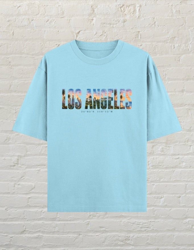 CoreTeez baby blue oversized cotton unisex t-shirt featuring a Los Angeles cityscape graphic print on the front.