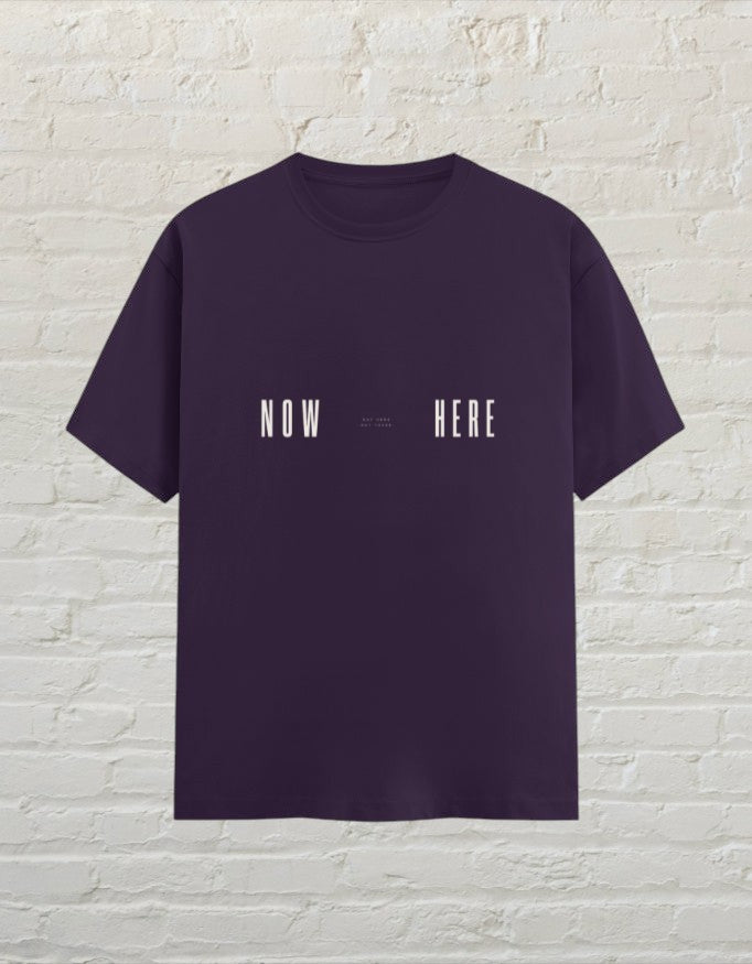 CoreTeez unisex  purple 100% cotton t-shirt featuring a minimalist white NOW HERE graphic print