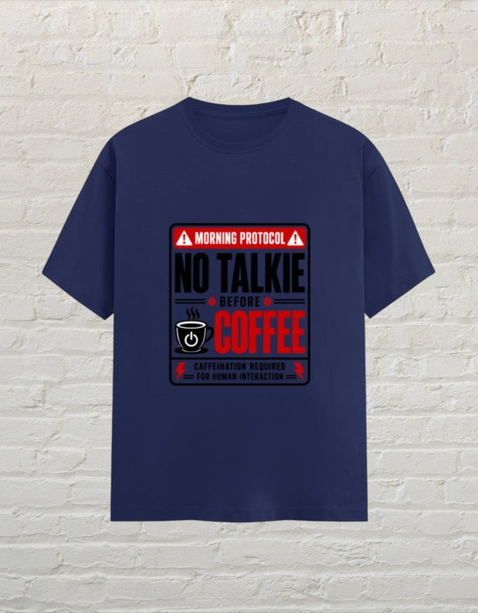 CoreTeez royal blue cotton unisex t-shirt featuring a No Talkie Before Coffee graphic print on a brick wall background.