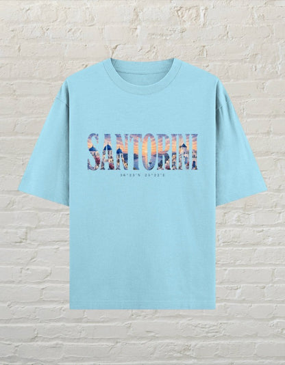 CoreTeez baby blue oversized cotton t-shirt featuring a Santorini travel graphic print on the front.