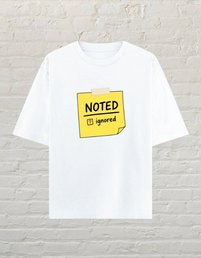 CoreTeez white oversized unisex cotton t-shirt featuring a yellow sticky note graphic with Noted and Ignored text.