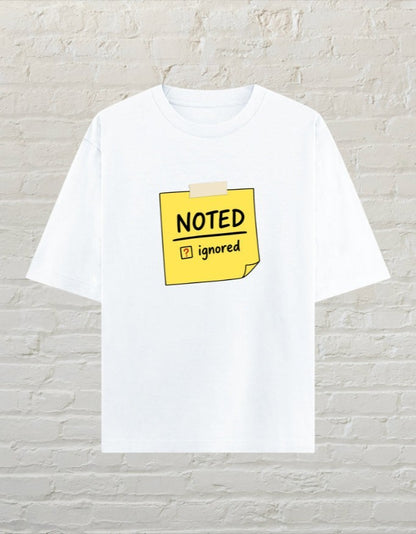 CoreTeez white oversized unisex cotton t-shirt featuring a yellow sticky note graphic with Noted and Ignored text.